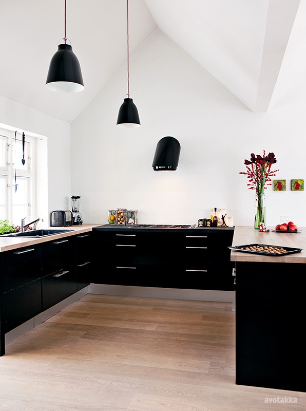 Spacious and light-filled black and white kitchen. Lovely fruit and flower details. Photo via avotakka 